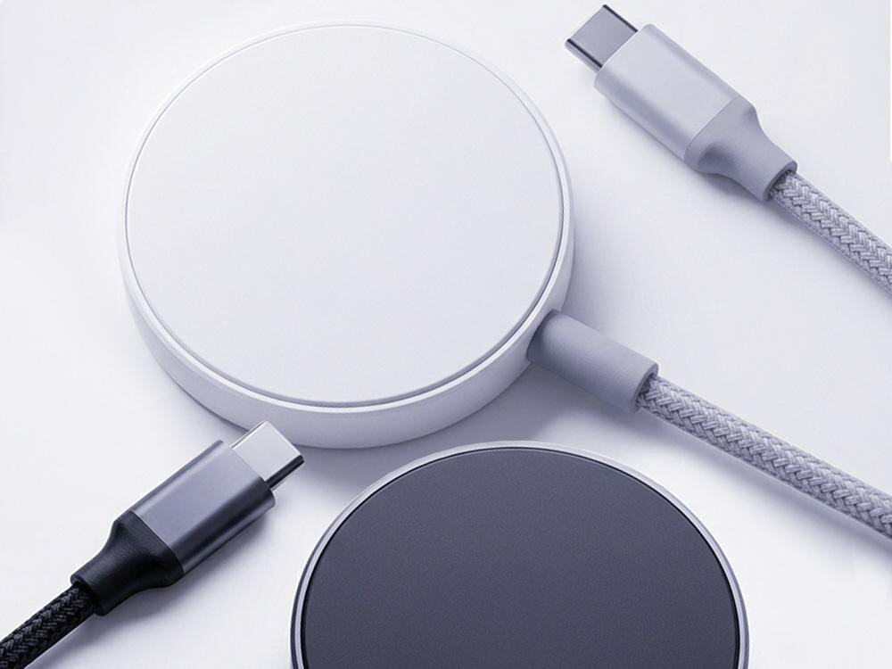 Na obrazie widoczne są dwie okrągłe ładowarki indukcyjne w kolorach białym i ciemnoszarym, z podłączonymi kablami USB-C. Kable mają różne tekstury, jeden jest pleciony, a drugi gładki.