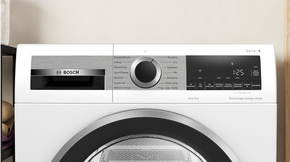 SUSZARKA BOSCH WQG241MSPL Na zdjęciu jest panel sterowania suszarki: podajnik na środki, pokrętło wyboru programów (np. koszule, bawełna, syntetyki, ręczniki) i elektroniczny wyświetlacz z dodatkowymi opcjami. Całość wygląda estetycznie i funkcjonalnie Wyświetlacz panel sterowanie funkcje programy