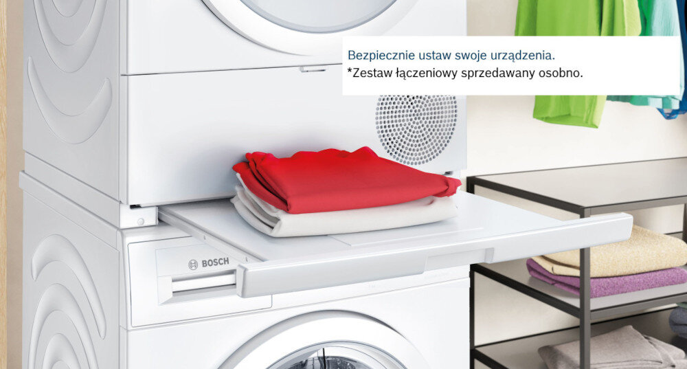 SUSZARKA BOSCH WQG241MSPL Na zdjęciu widoczna jest pralka i suszarka ustawione jedna na drugiej w zabudowie z drewnianymi elementami. Przed pralką wysunięta jest praktyczna półka złożonym ręcznikiem, ułatwiająca odkładanie prania. Obok stoi kosz na bieliznę, a z prawej strony widać zieloną roślinę doniczkową ustawienie na pralce stabilność urządzeń łącznik suszarka-pralka wygodne przenoszenie prania bezpieczne użytkowanie szybkie pranie i suszenie