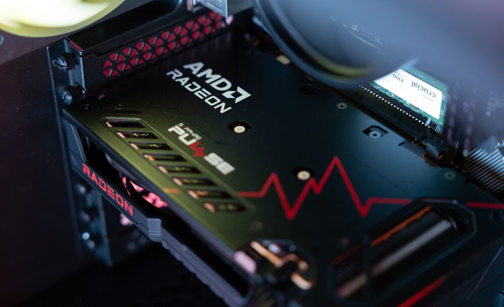 Zbliżenie na wnętrze komputera z widoczną kartą graficzną z logo \'AMD RADEON\' oraz napisem \'PULSE\'.