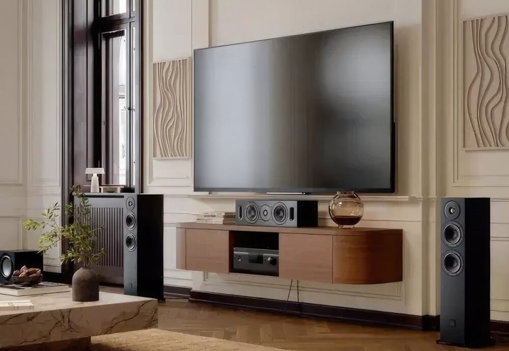 Kolumny podłogowe DALI Sonik 5 przetworniki 5,25 cala Clarity Cone naturalne średnie tony, kolumny stojące obok komody nad telewizorem w pomieszczeniu