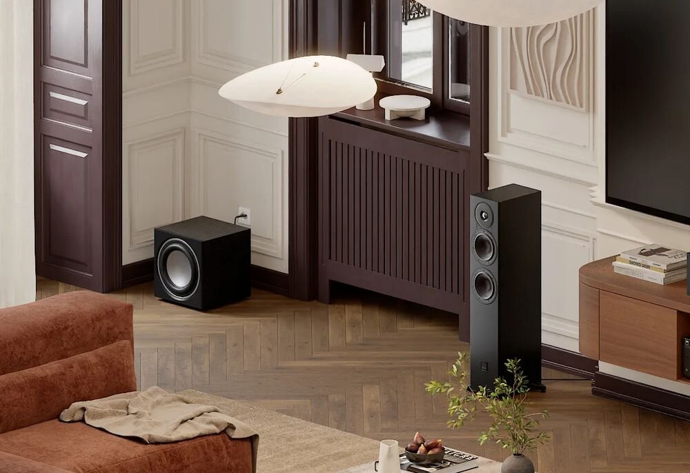 Kolumny podłogowe DALI Sonik 5 mocny bas podwójne woofery dynamika dźwięku, kolumna stojąca obok komody nad telewizorem w pomieszczeniu