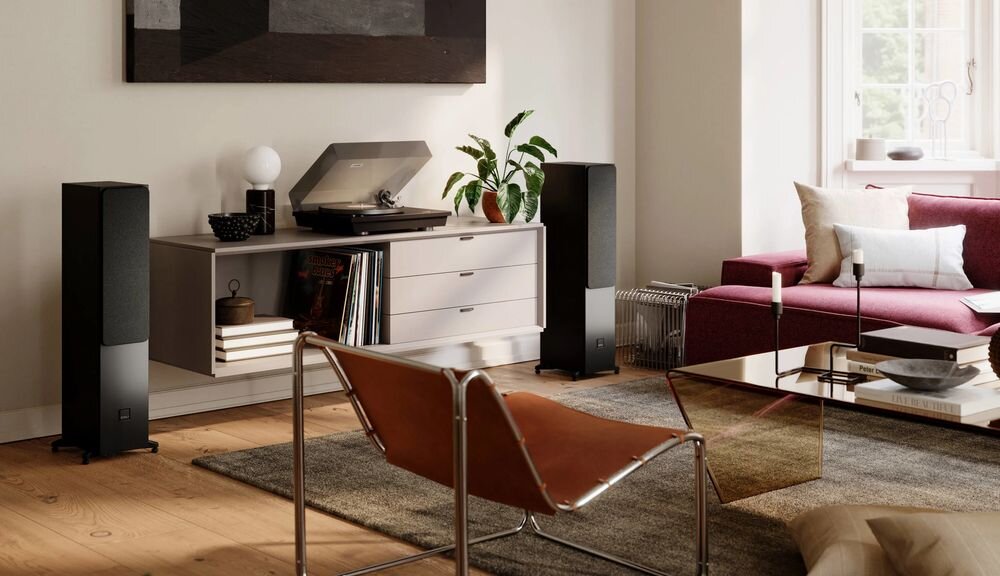Kolumny podłogowe DALI Sonik 5 obudowa MDF stabilność redukcja drgań czyste brzmienie, kolumny stojące obok komody nad telewizorem w pomieszczeniu