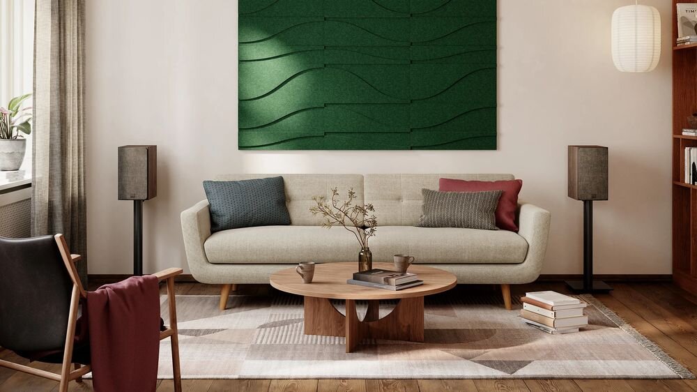 Podstawkowe kolumny głośnikowe DALI Sonik 3 smukła konstrukcja mocne brzmienie stereo, kolumny stojące na podstawkach obok kanapy w pomieszczeniu