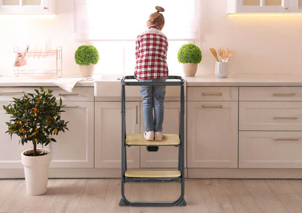 Krzesełko do karmienia NENO Sapori 4w1 Czarny Pomocnik w kuchni Możliwość ustawienia przy blacie rozwija samodzielność i ciekawość świata dziecko stoi na krzesełku przy blaci tyłem do obiektywu