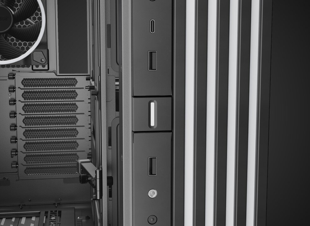 Komputer MAD DOG GeForce RTX5090 DLSS 4 Reflex Edition 2 BQ900FX-A02WR64WP Zbliżenie na fragment czarnej obudowy z portami USB, wejściem słuchawkowym i przyciskiem, umieszczonymi obok pionowych listew z wielokolorowym efektem świetlnym