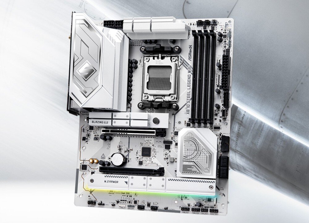 Komputer MAD DOG GT302-WH-A01WR32WH Płyta główna o biało-srebrnej stylistyce ze srebrnymi radiatorami i gniazdami umieszczona na tle metalowej konstrukcji z nitami