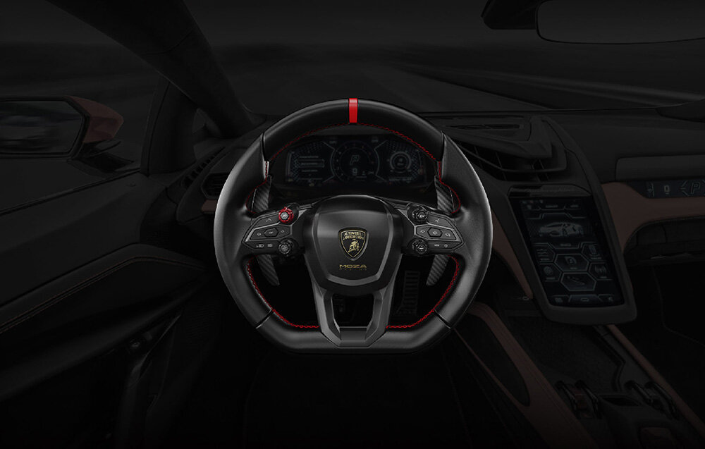 Wnętrze samochodu z widoczną kierownicą z logo Lamborghini i napisem \'MOZA\'. W tle widoczny jest cyfrowy panel kontrolny oraz elementy deski rozdzielczej.