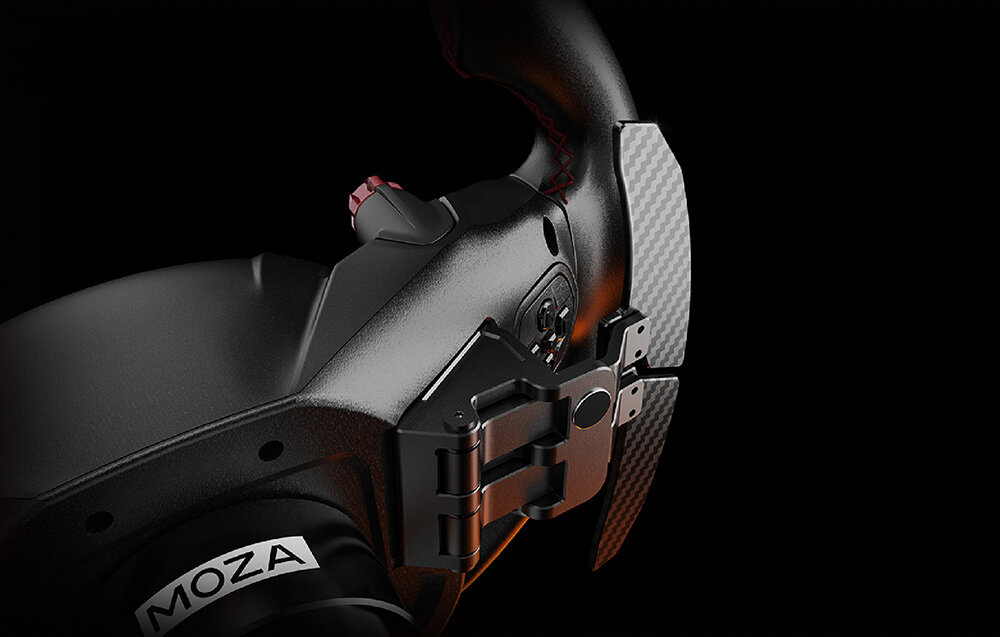 Zbliżenie na czarną kierownicę z widocznym logo \'MOZA\' oraz elementami z włókna węglowego i metalowymi przyciskami.
