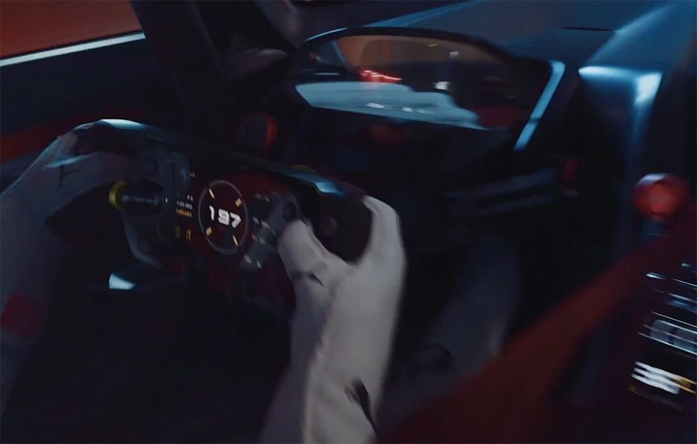 Kierownica MOZA RACING Porsche MISSION R Zbliżenie na trzymaną w dłoniach kierownicę z wyświetlaczem samochodu wyścigowego rama aluminium obrabiane CNC sztywność konstrukcji uchwyty pokryte materiałem o strukturze przypominającej zamsz stabilny chwyt