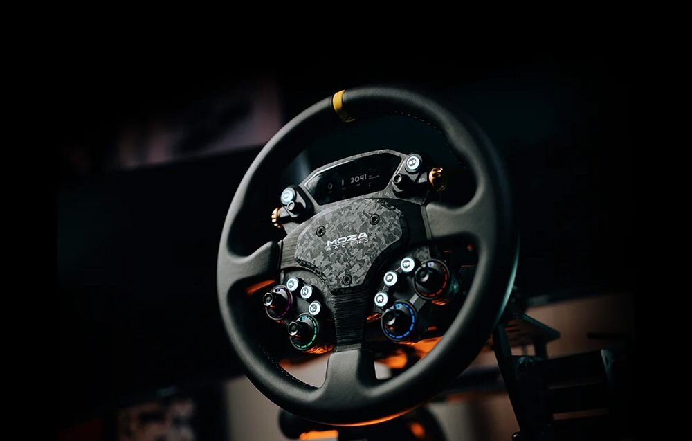 Kierownica MOZA CS Pro RS093, CFRP, włókno, bezwładność, Direct Drive, Kierownica MOZA Racing z wyświetlaczem i przyciskami w ciemnym otoczeniu.