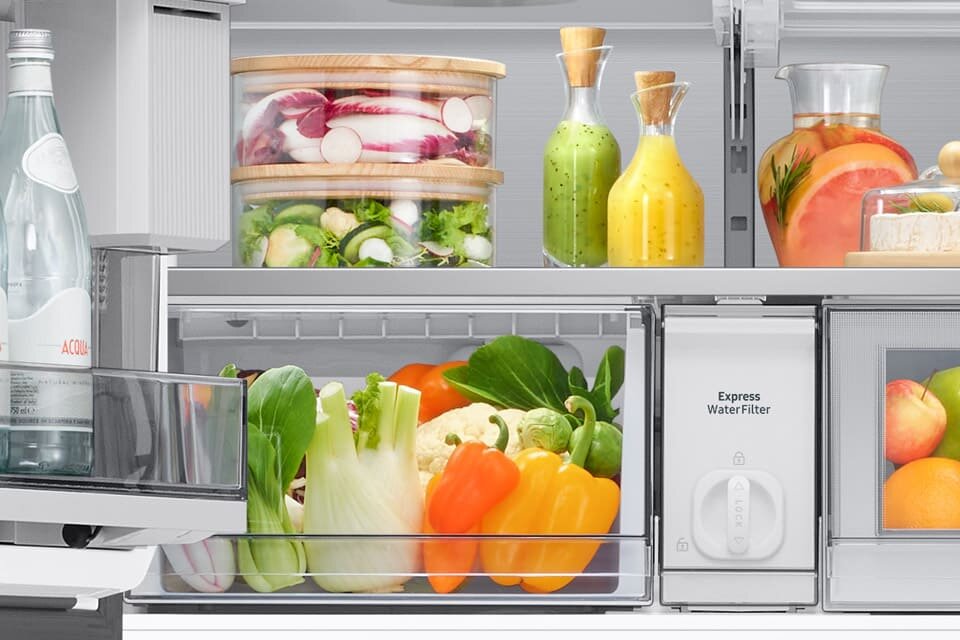 Szuflada w lodówce przeznaczona na przechowywanie warzyw i owoców, z różnorodnymi produktami w środku.