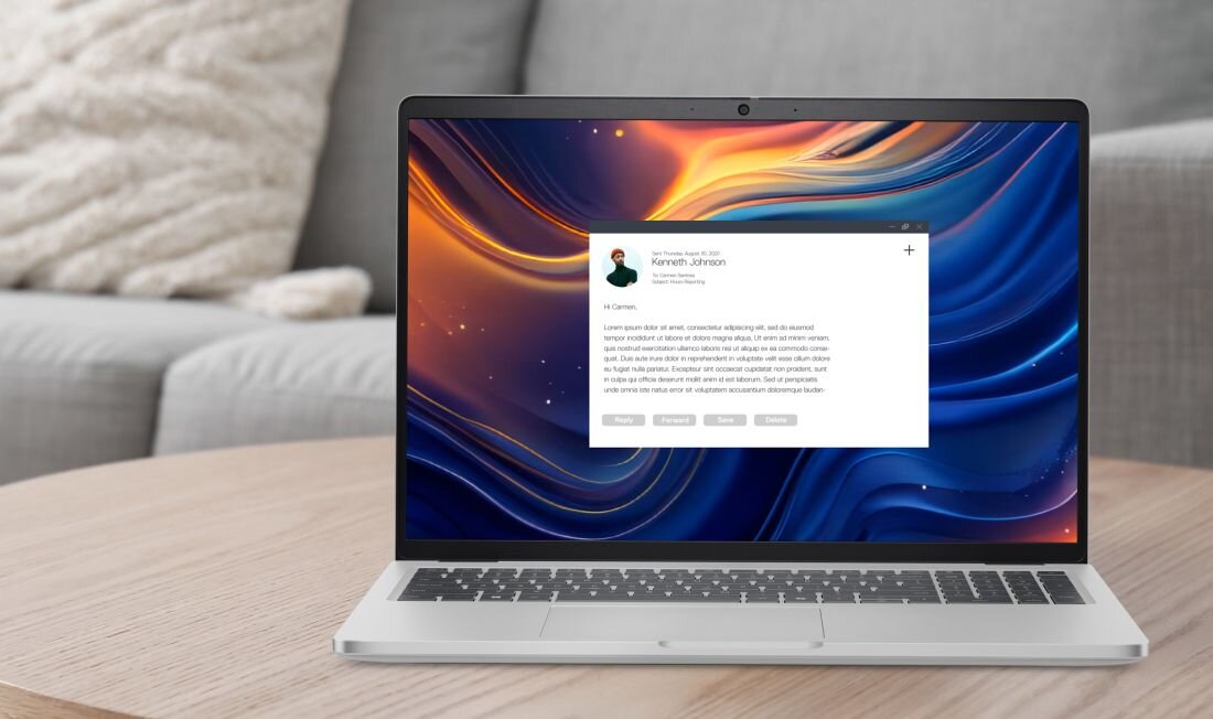 Laptop z wyświetlaczem pokazującym kolorową, abstrakcyjną grafikę oraz okno z tekstem i zdjęciem profilowym. W tle widoczna jest szara sofa.