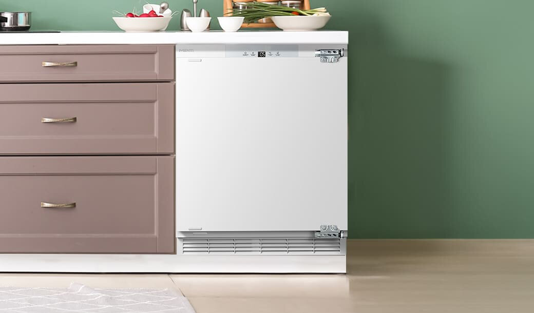 Lodówka MPM-116-CJI-17/E obok szafek kuchennych.