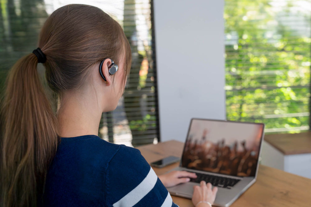 Słuchawki powietrzne XMUSIC XWS550K Czarny wbudowany mikrofon klawisz funkcyjny odbieranie kończenie połączeń - osoba siedząca przed komputerem w słuchawkach