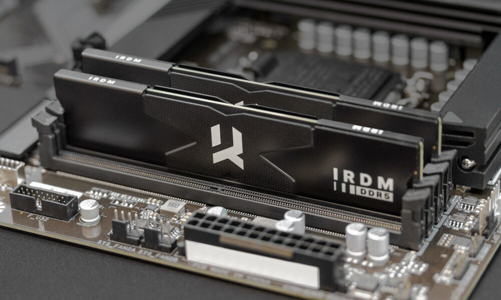 Komputer MAD DOG Powered by MSI F321R-A04WR32WP Dwa moduły pamięci RAM DDR5 marki IRDM zamontowane w gniazdach płyty głównej, widok z bliska na ich czarne radiatory z białym logo, pamięć RAM, pojemność, taktowanie, opóźnienia, podkręcenie