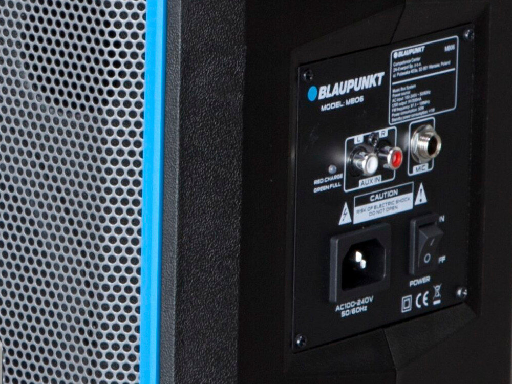 Zdjęcie przedstawia panel tylni głośnika z logo BLAUPUNKT i modelem MB06. Widoczne są złącza AUX IN, MIC oraz gniazdo zasilania z napisem AC100-240V 50-60Hz.