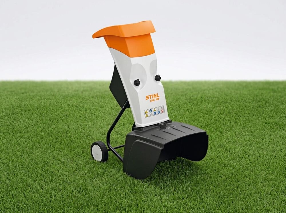 Rozdrabniacz do gałęzi STIHL GHE 105 elektryczny 2200W średnica cięcia 35mm, silnik, zasilanie, moc, rozdrabnianie, Pomarańczowo-biały rozdrabniacz stojący na trawniku.