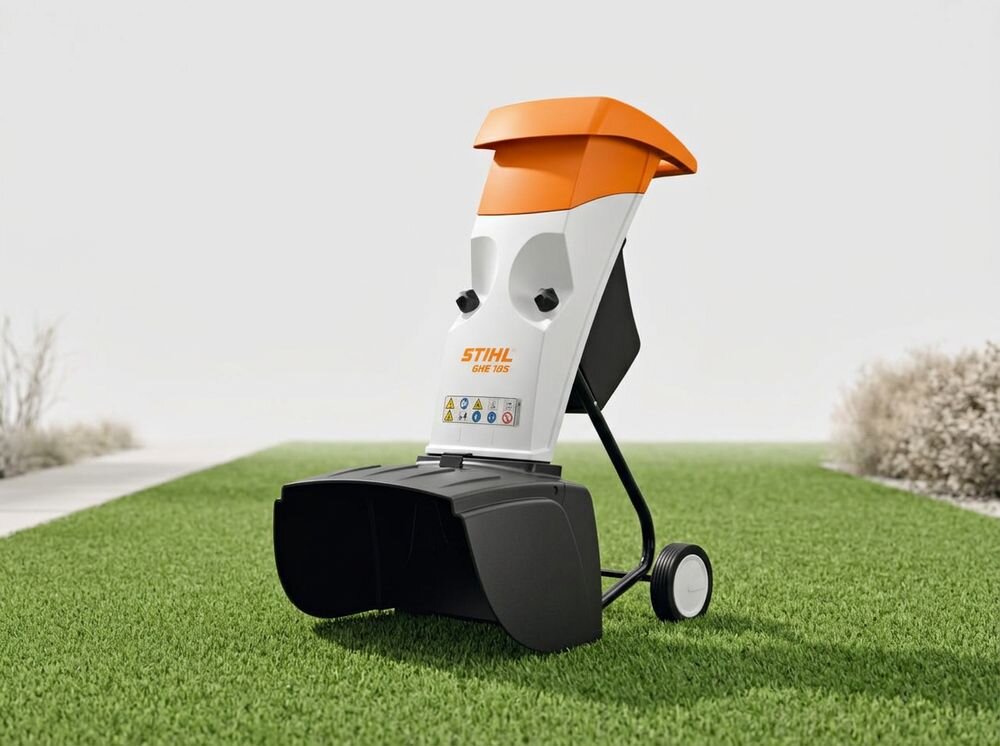 Rozdrabniacz do gałęzi STIHL GHE 105 elektryczny 2200W średnica cięcia 35mm, panel, włącznik, ochrona, bezpiecznik, Rozdrabniacz do gałęzi ustawiony na zielonej trawie.