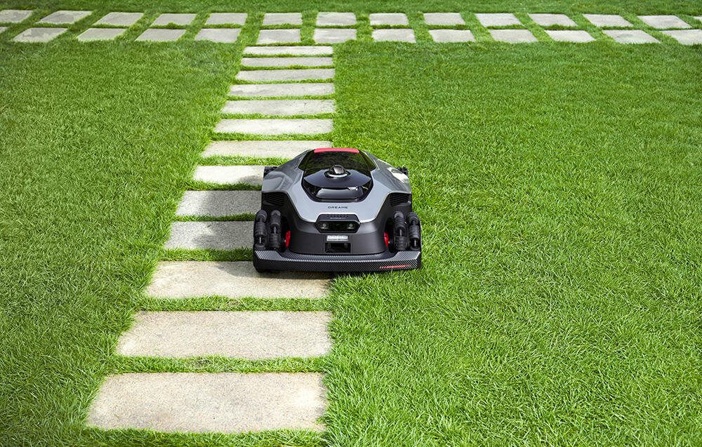 Robot koszący DREAME A3 AWD Pro 2500 trawnik robot ustawiony na trawie chodnik zaawansowana technologia AI samodzielne koszenie zadbany ogród