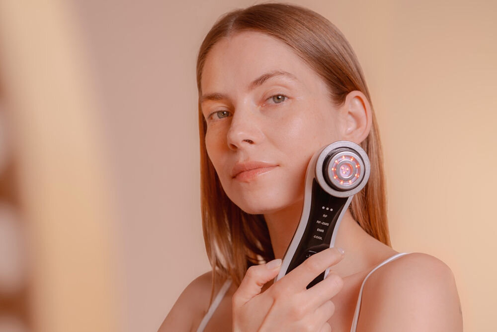 Urządzenie do mezoterapii GARETT BEAUTY Fresh Skin Pro Biały kobieta trzymająca urządzenie w dłoni czarny przód czerwone światło diody jasne tło do mezoterapii bezigłowej intensywne nawilżenie, ujędrnienie skóry promienny wygląd 3 poziomy mocy 4 tryby pracy dostosowanie zabiegu technologia EMS, terapia światłem, wibracje soniczne ciepły kompres profesjonalna pielęgnacja pomaga zredukować zmarszczki, poprawić elastyczność skóry przywrócenie zdrowego kolorytu skuteczna pielęgnacja