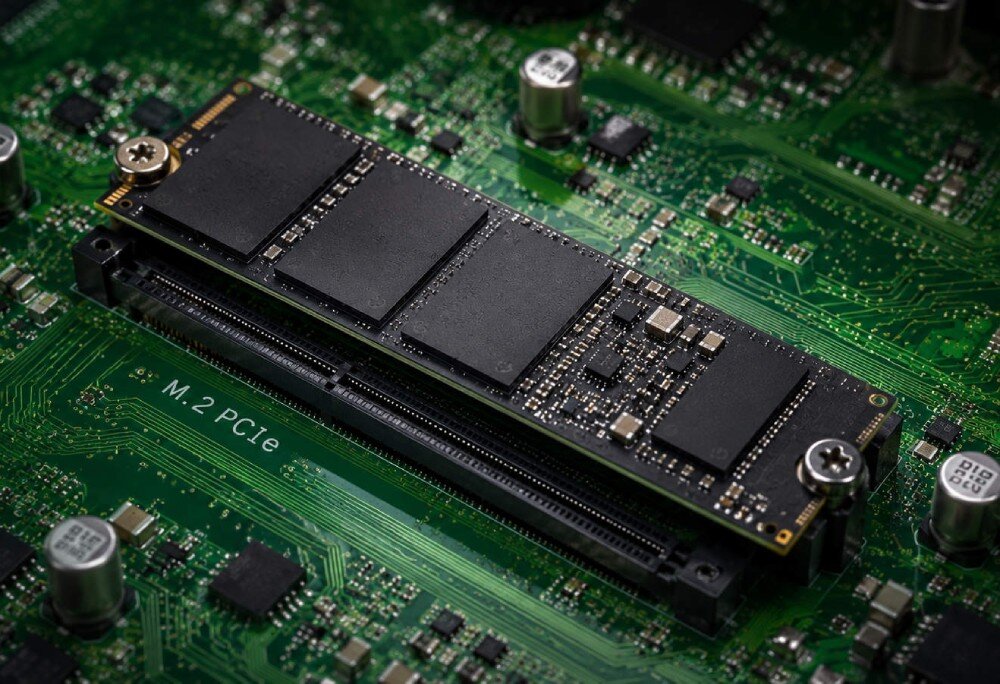 Komputer ACER Nitro N20-101-RPL Dysk SSD typu M.2 PCIe zamontowany w gnieździe na zielonej płycie głównej, przykręcony małą śrubką, dysk, pojemność, interfejs