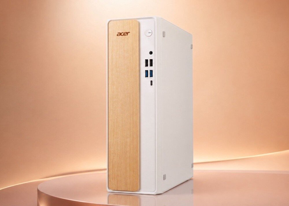 Biały komputer stacjonarny z drewnianym panelem frontowym, na którym widnieje logo \'acer\'. Obok panelu znajdują się porty USB i przycisk zasilania.