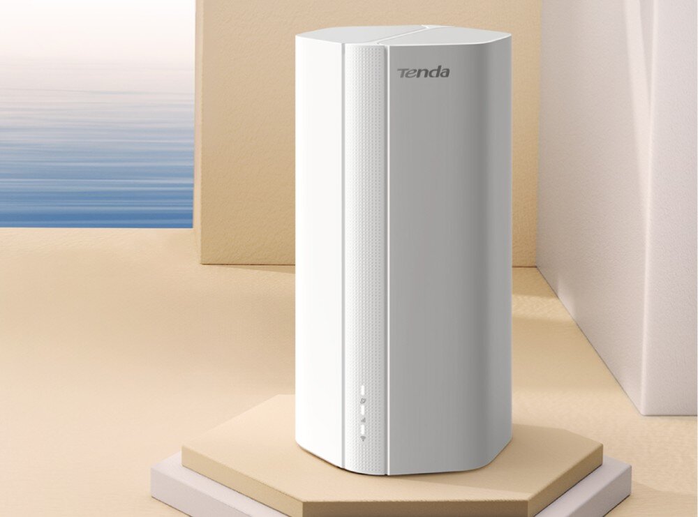 Na obrazie widoczny jest biały router o nowoczesnym designie, stojący na sześciokątnej podstawie. Na urządzeniu znajduje się logo \'tenda\'.