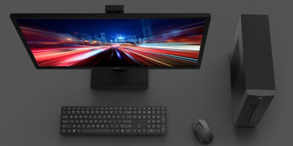 Komputer ACER Aspire XC-1780 Kompletny zestaw komputerowy z lotu ptaka: monitor z barwną tapetą, klawiatura, mysz oraz obudowa komputera obok, wszystko na szarym blacie