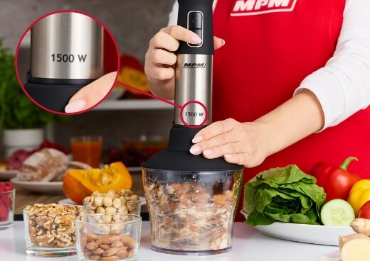 Kobieta blenduje orzechy w pojemniku. Zbliżenie na moc blendera MBL-42M - 1500 W.