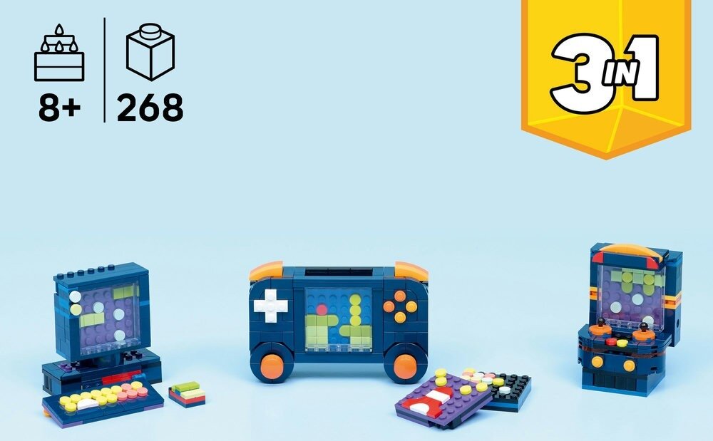 Na jasnoniebieskim tle znajdują się trzy modele z klocków LEGO przedstawiające retro konsole do gier. W lewym górnym rogu widnieją ikony z oznaczeniem \'8+\' i \'268\', a w prawym górnym rogu żółty symbol \'3 in 1\'.