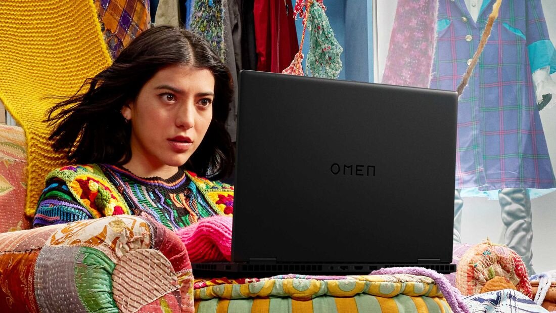 Laptop HP Omen 16 - Kobieta na kanapie, używająca laptopa HP Omen 16, w komfortowej i domowej atmosferze.   