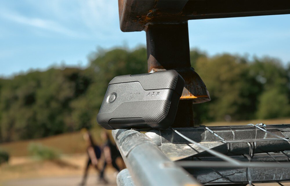 Router CAT CQ10-SAB-RON-NN 5G Czarny sprzęt elektroniczny z napisem 'CAT' i trzema diodami świetlnymi, położony na metalowym elemencie barierki w plenerze