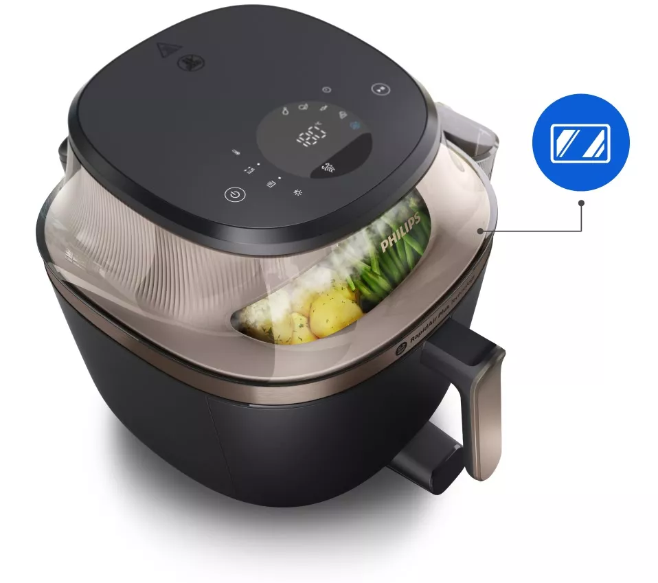 Frytkownica beztłuszczowa z przezroczystą pokrywą, przez którą widać warzywa. Na urządzeniu widoczne jest logo \'PHILIPS\' oraz panel dotykowy z ikonami i wyświetlaczem cyfrowym.