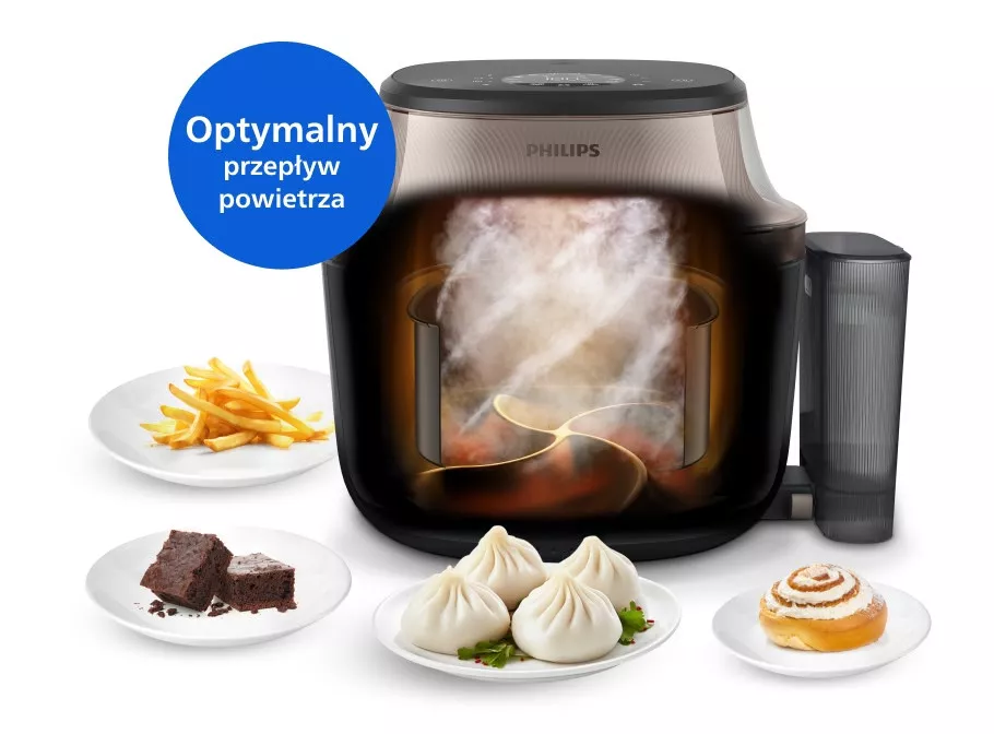 Na obrazie widoczna jest frytkownica beztłuszczowa marki PHILIPS z przezroczystym frontem, przez który widać przepływ powietrza. Obok urządzenia znajdują się talerze z frytkami, ciastem, bułeczkami i cynamonową bułką, a na niebieskim tle napis \'Optymalny przepływ powietrza\'.