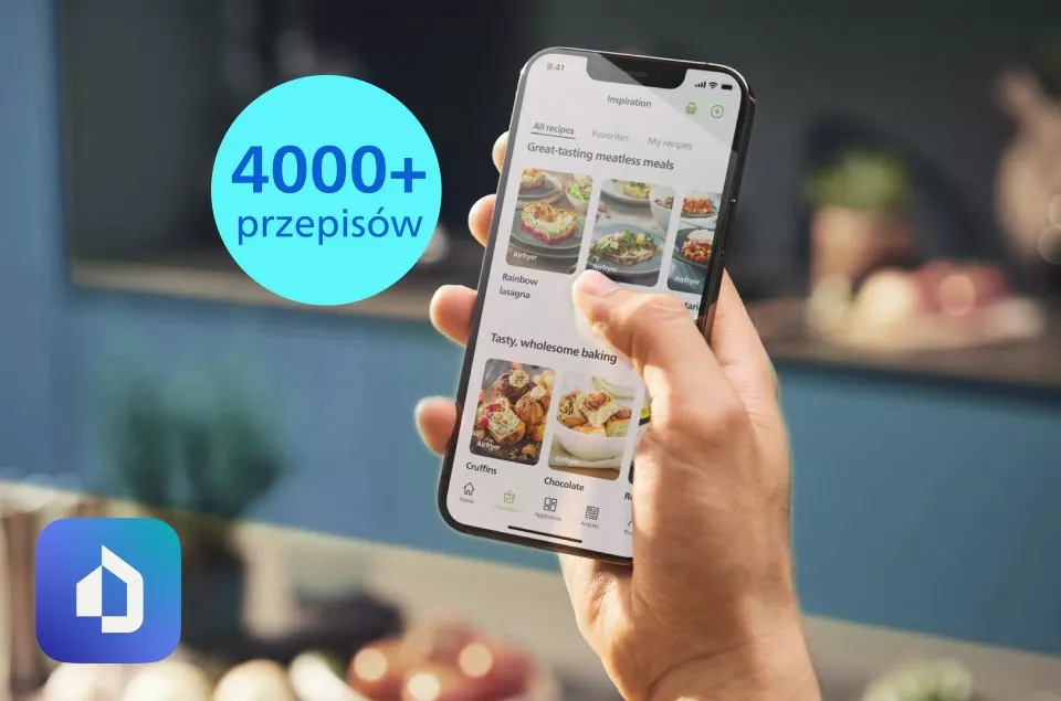 Osoba trzyma smartfon z aplikacją wyświetlającą przepisy kulinarne, a obok widoczny jest niebieski okrąg z napisem \'4000+ przepisów\'. W lewym dolnym rogu znajduje się niebieskie logo z białym symbolem domu.
