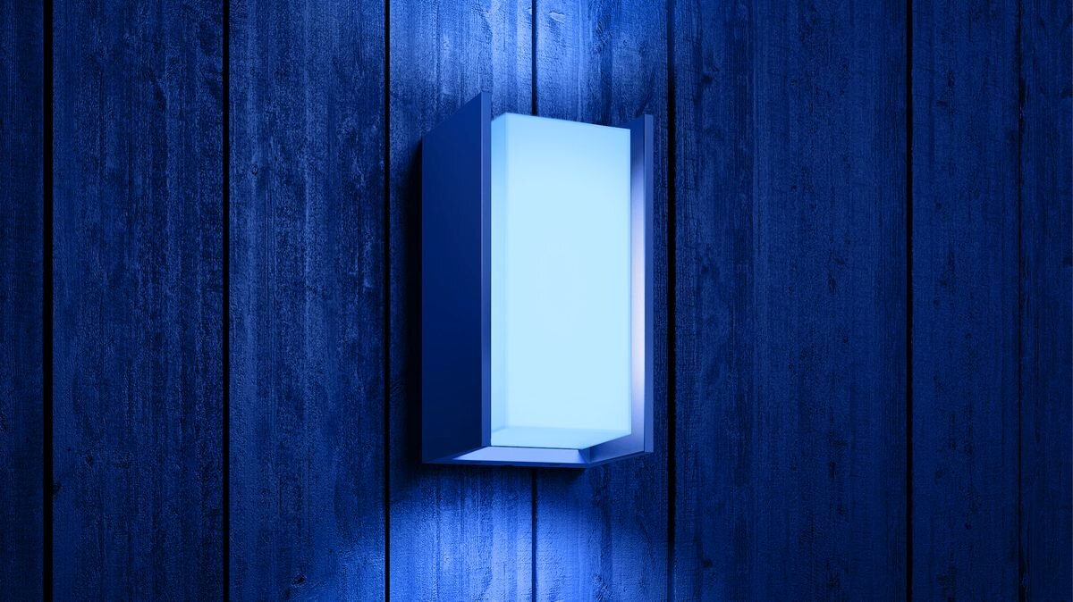 Kinkiet zewnętrzny PHILIPS HUE Turaco (Bluetooth, ZigBee), automatyczne, lokalizacja, wejście, harmonogram, Kinkiet Philips Hue Turaco świecący na niebiesko na drewnianej ścianie.