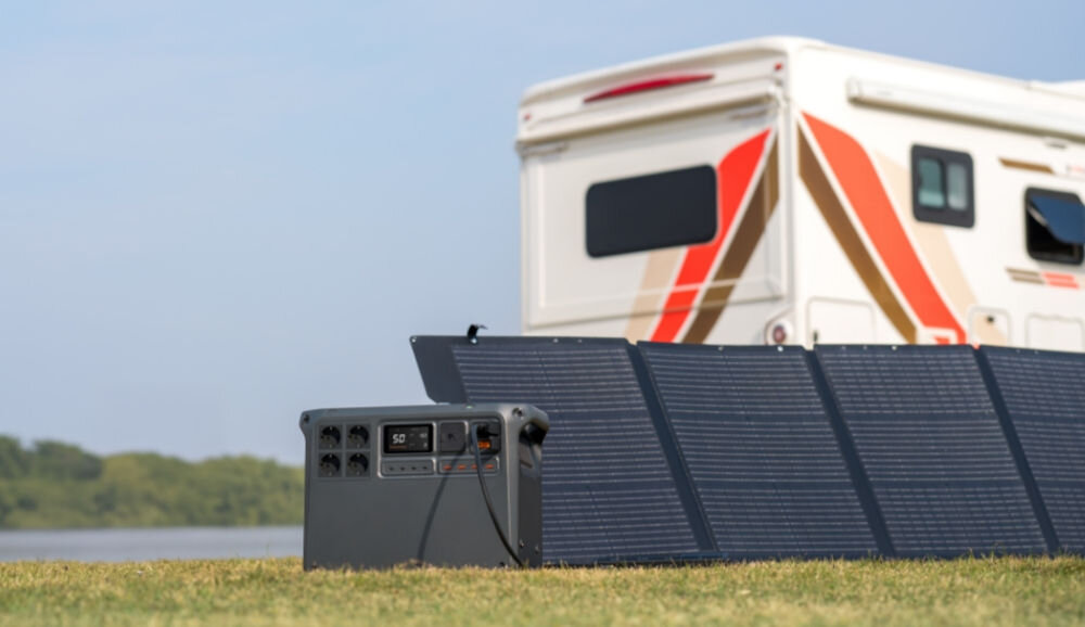 Stacja zasilania DJI Power 2000 2048 Wh Bank energii, porty, kompatybilność, oferta, panele, fotowoltaiczne, w tle kamper, na pierwszym planie stacja zasilania wraz z panelem fotowoltaicznym