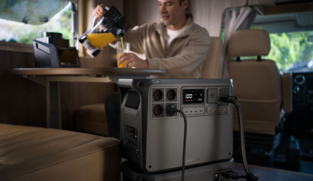 Stacja zasilania DJI Power 2000 2048 Wh Bank energii, awaryjne, UPS, 10 ms, energia, mężczyzna siedzi w kamperze, na pierwszym planie stacja zasilania