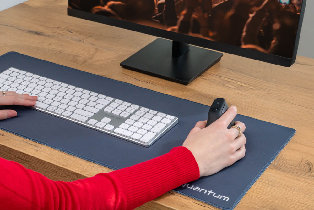 Mysz XQUANTUM WM700K Zbliżenie na dłoń spoczywającą na myszy pionowej XQUANTUM, prezentujące naturalny chwyt redukujący napięcie nadgarstka.