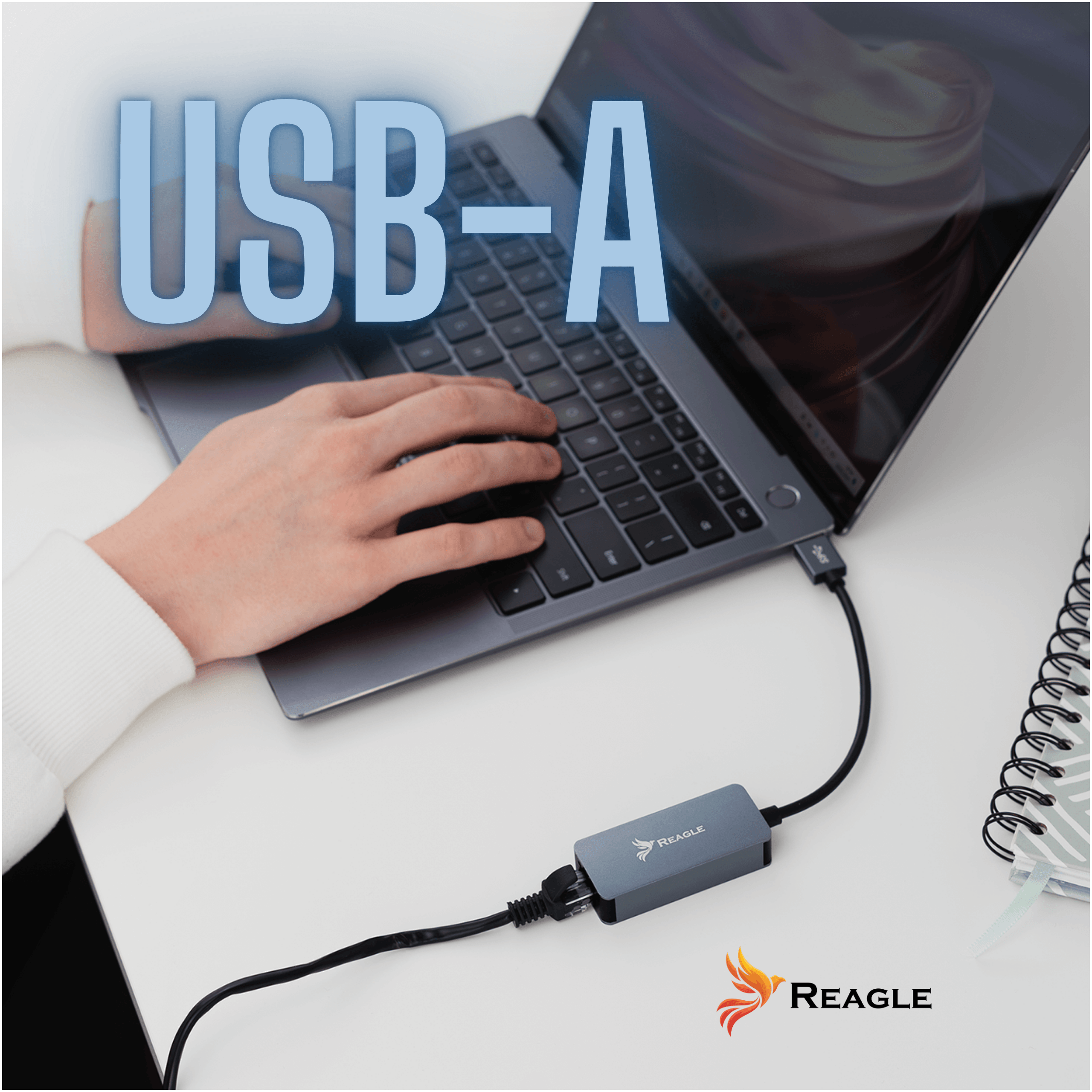 Osoba używa laptopa, do którego podłączony jest adapter sieciowy z logo Reagle. Na obrazie widoczny jest duży napis \'USB-A\'.