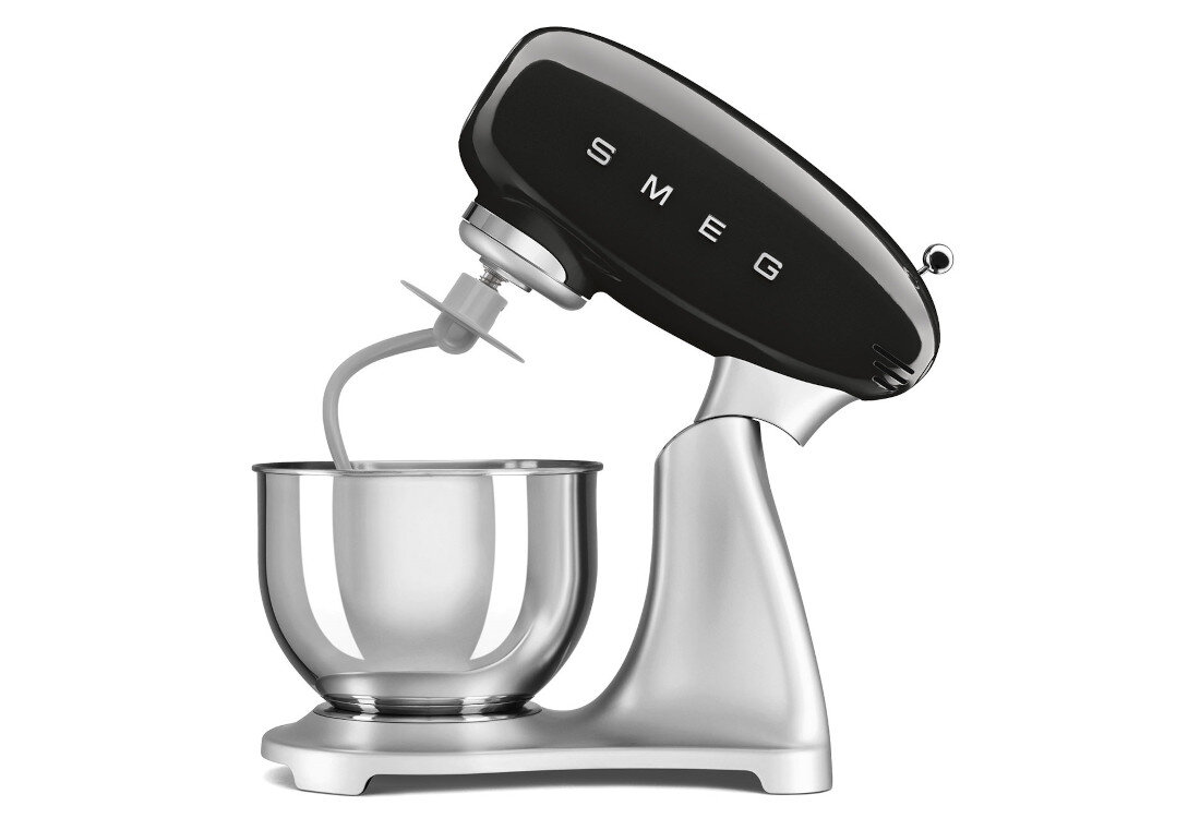 Czarno-stalowy robot kuchenny planetarny z logo \'SMEG\' na górnej części. Urządzenie posiada metalową misę i przystawkę do mieszania.