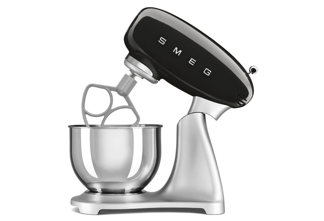 Czarno-stalowy robot kuchenny planetarny z logo \'SMEG\' na górnej części. Urządzenie posiada metalową misę i mieszadło w kształcie litery P.