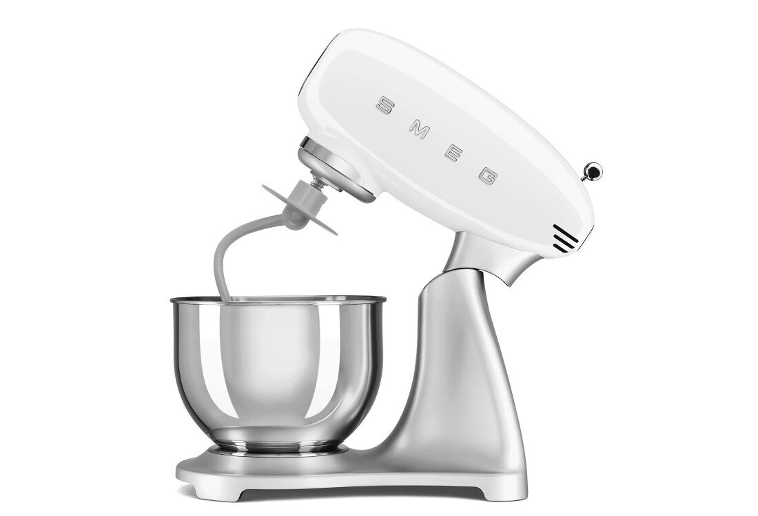 Na obrazie widoczny jest biało-stalowy robot kuchenny z misą i mieszadłem. Na obudowie znajduje się napis \'SMEG\'.