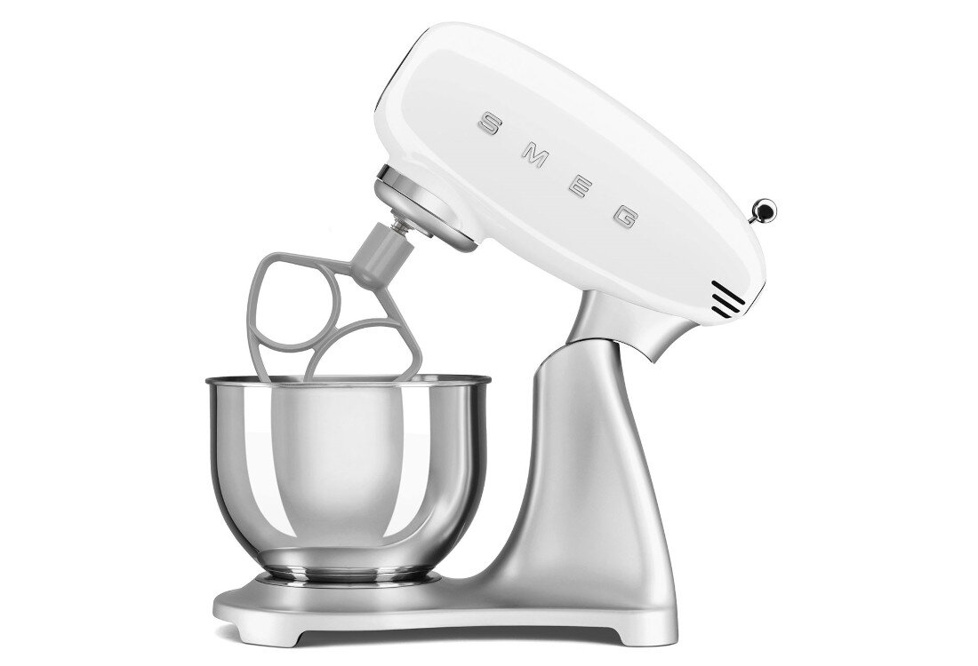 Na obrazie widoczny jest biało-stalowy robot kuchenny planetarny z logo SMEG na górnej części. Urządzenie posiada metalową misę i mieszadło w kształcie litery P.