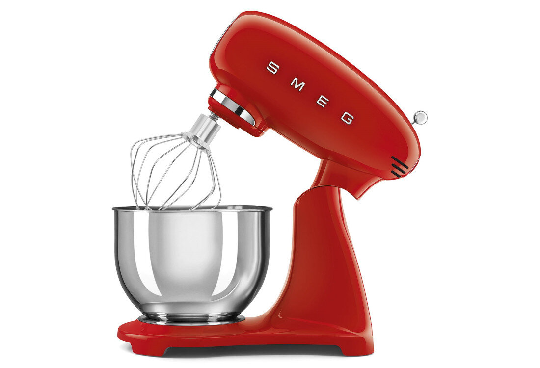 Czerwony robot kuchenny z metalową misą i trzepaczką, na obudowie widoczne logo \'SMEG\'.