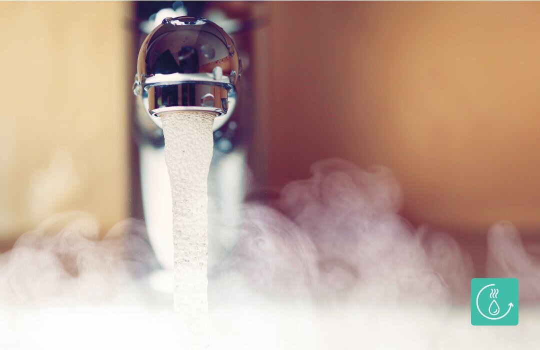 ZMYWARKA GORENJE GV520E15 Strumień gorącej wody lecący z chromowanej baterii kuchennej, otoczony parą wodną, co ilustruje możliwość podłączenia zmywarki do ciepłej wody w celu oszczędności energii