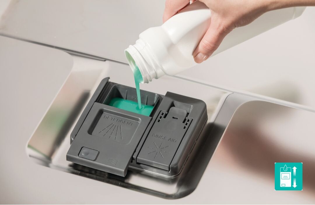 ZMYWARKA GORENJE GV520E15 Zbliżenie na dozownik detergentu i nabłyszczacza w zmywarce, do którego wlewany jest zielony płyn z białej butelki, symbolizujące łatwe uzupełnianie środków myjących