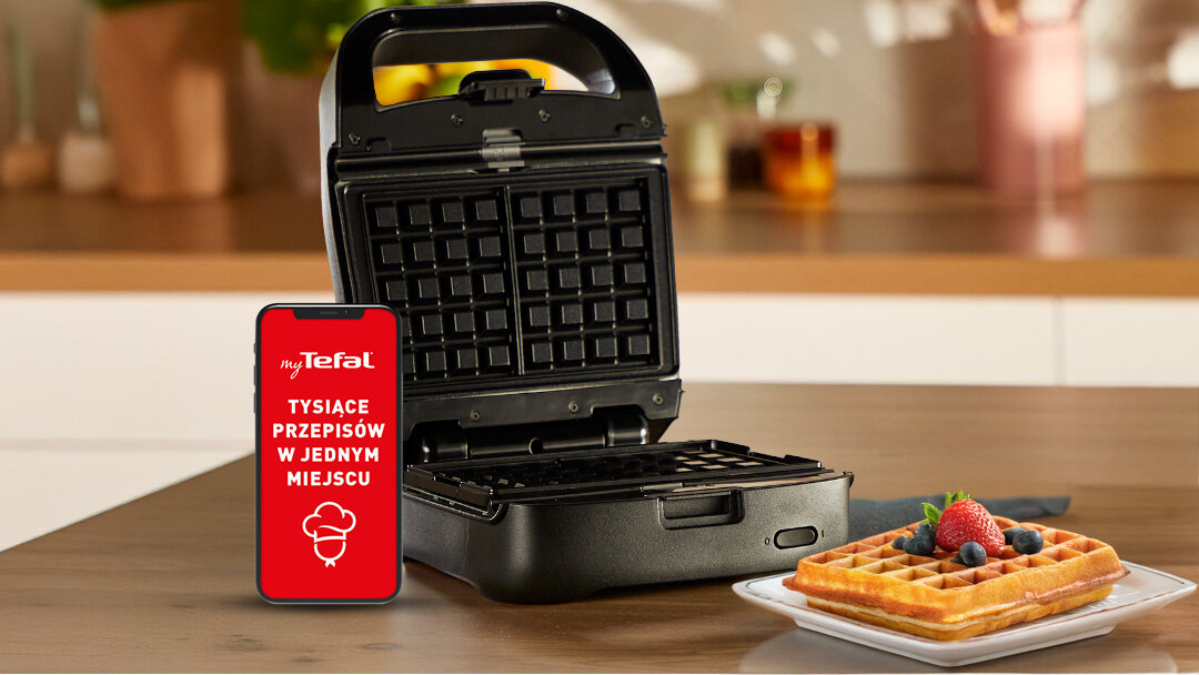 Opiekacz SW862B na blacie kuchennym, z aplikacją myTefal na ekranie smartfona.