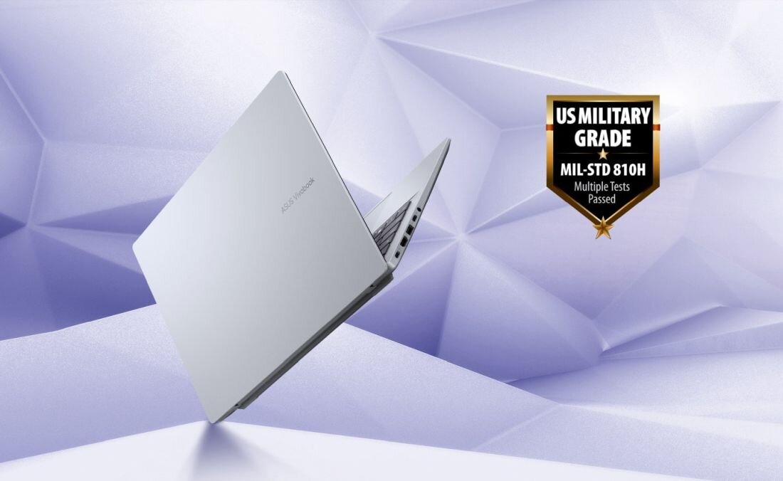 Srebrny laptop z widocznym logo ASUS na pokrywie, umieszczony na tle geometrycznych kształtów. Obok znajduje się odznaka z napisem \'US MILITARY GRADE MIL-STD 810H Multiple Tests Passed\'.